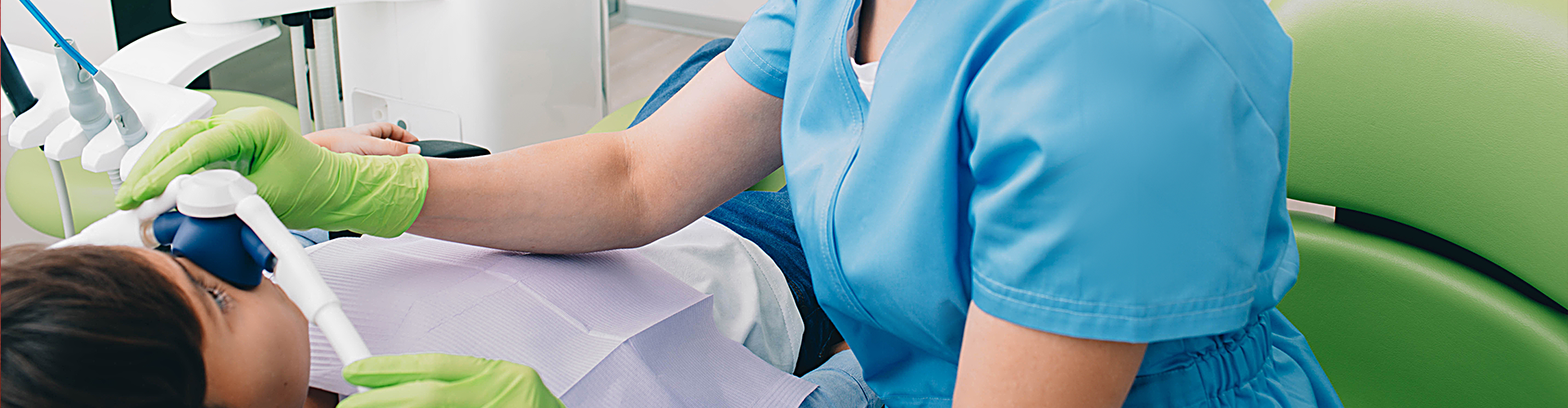 female dentist putting breathing mask over boy's nose